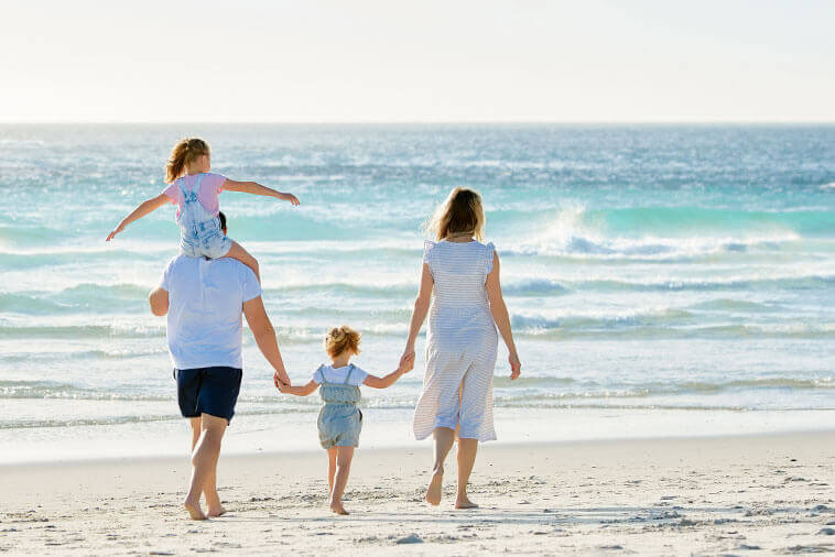 family enjoying a walk on the beach