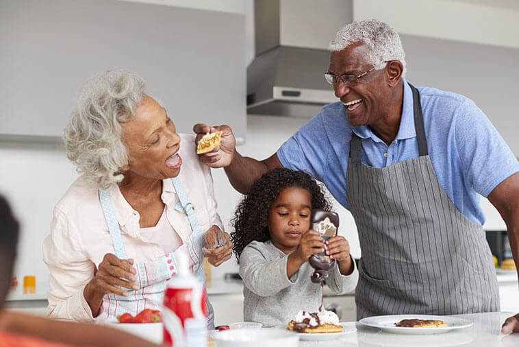 Grand parents and grandchild making breakfast