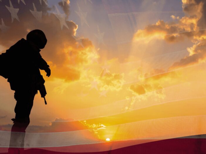 military man with sunset and American flag