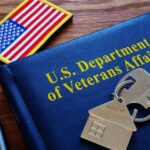 Blue booklet on a desk with an american flag patch and keys to a house