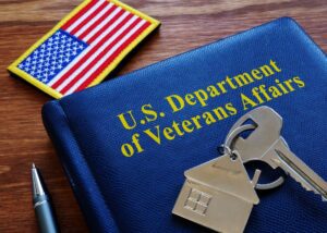 Blue booklet on a desk with an american flag patch and keys to a house