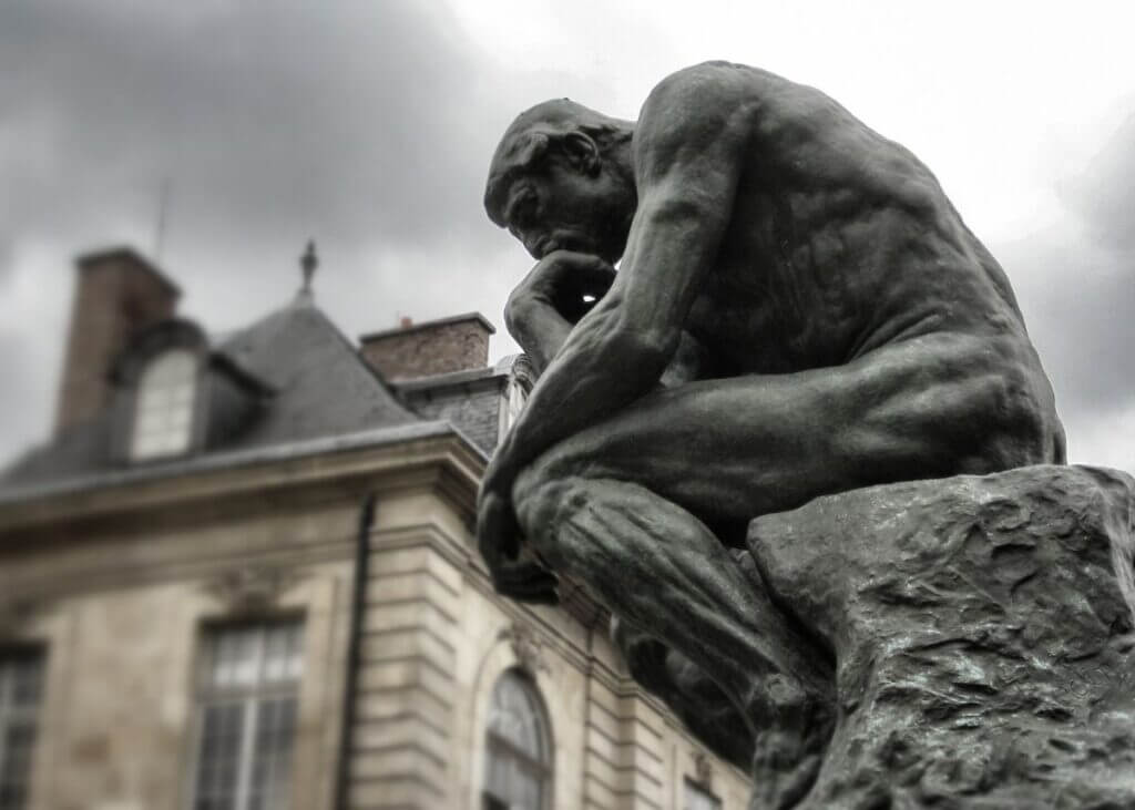 "The Thinker" statue. Statue is kneeled with his hand on his head thinking.