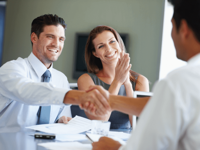 married couple shaking hands with professional