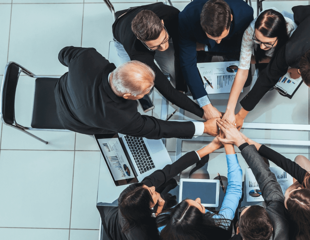 business team meeting with hands together in a circle