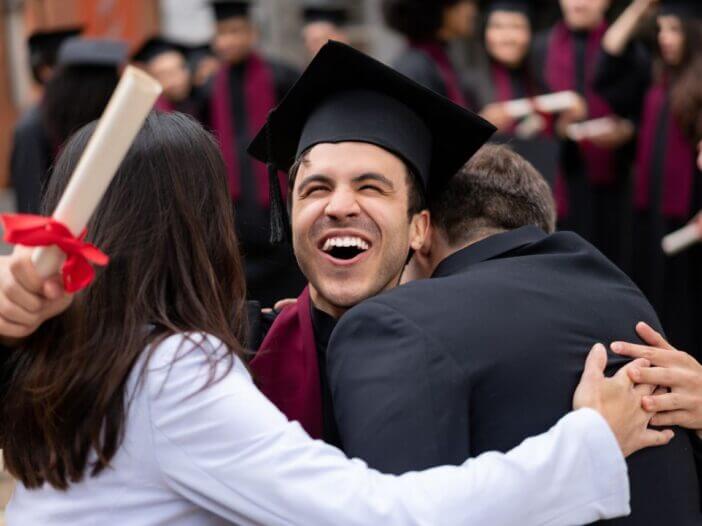 college graduate hugging parents