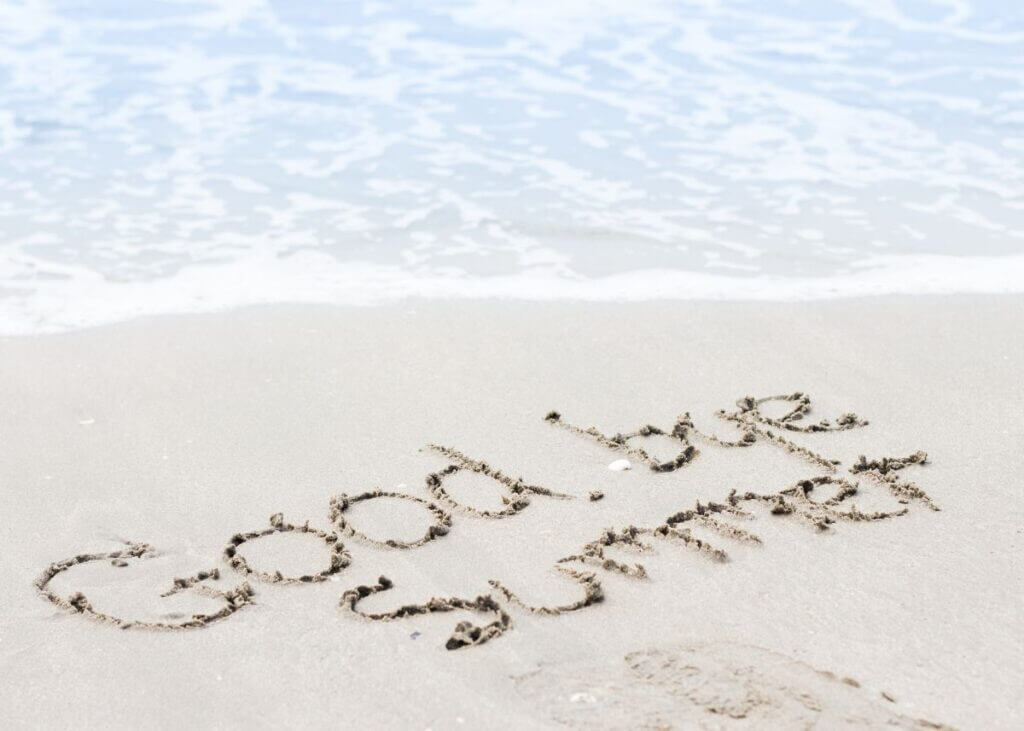 beach with good by summer written in the sand