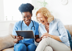 nurse reviewing clip board with elderly patient at home