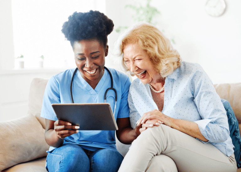 nurse reviewing clip board with elderly patient at home