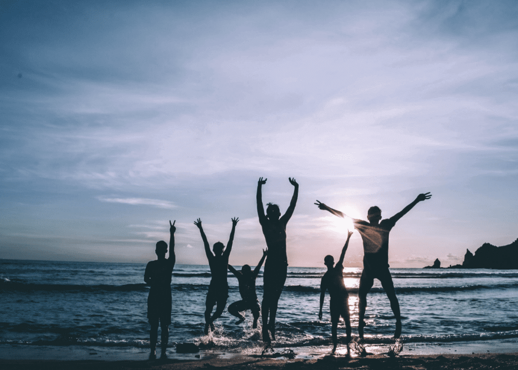 family jumping for joy on the beach