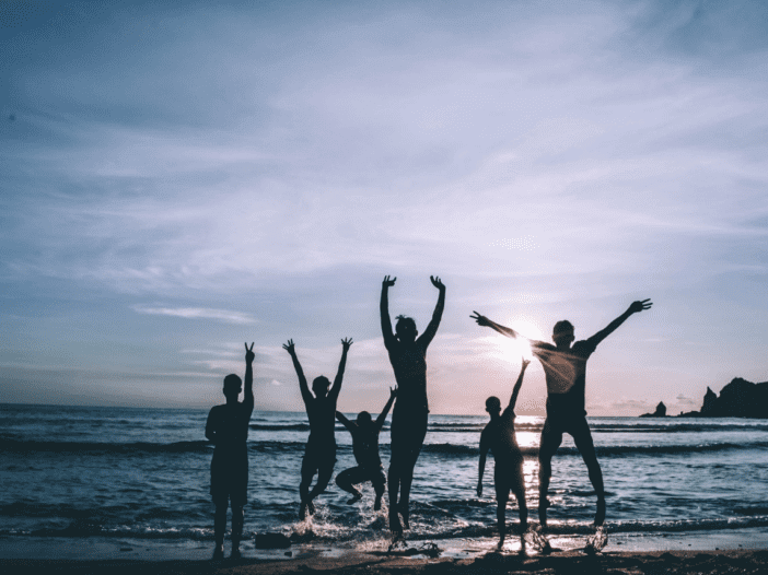 family jumping for joy on the beach