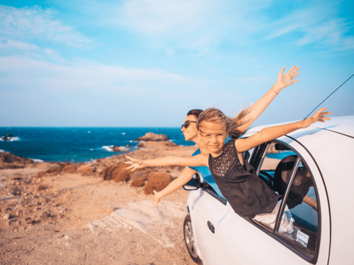 family on a roadtrip sticking their heads outside the car window