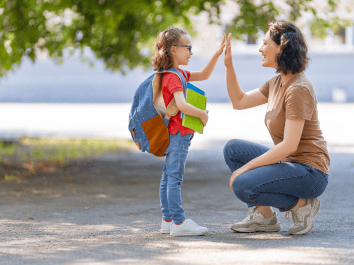 child ready for school giving mom a high five