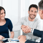 young couple shaking older advisors hand and smiling
