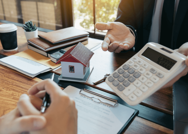 man with calculator and financial documents spread out on the table