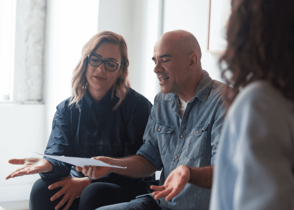 man and woman holding documents and shrugging