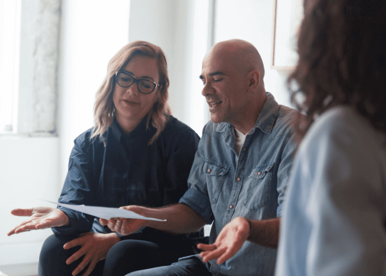 man and woman holding documents and shrugging