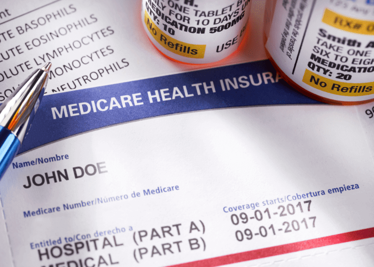 Medicare health insurance card with pill bottles next to it