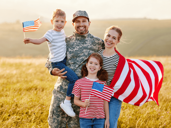 family with veteran and flags posing together