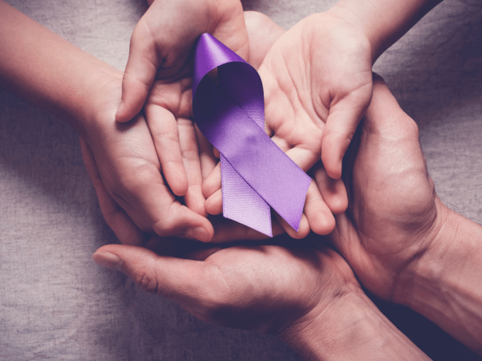 two pairs of hands holding Alzheimer's awareness ribbon