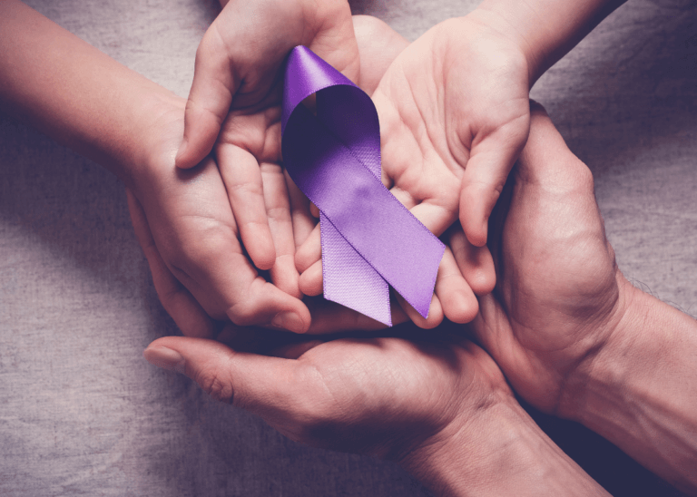 two pairs of hands holding Alzheimer's awareness ribbon