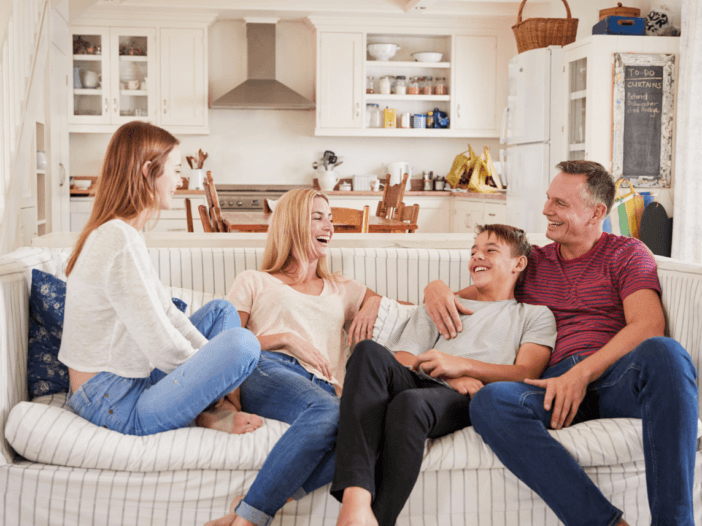 family with 18-year-old children sitting on couch