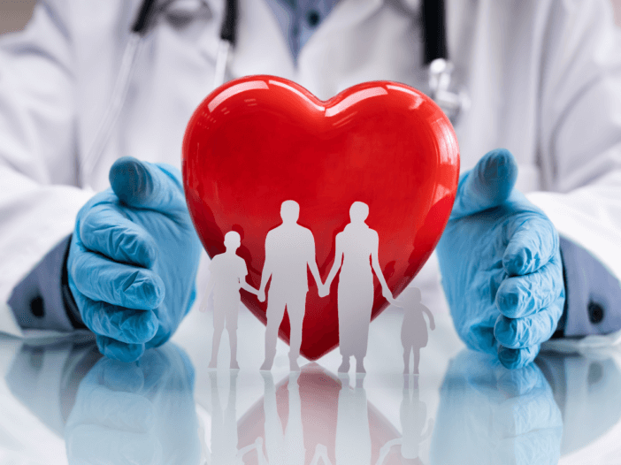 A Medicaid healthcare worker holding a heart with a family in between