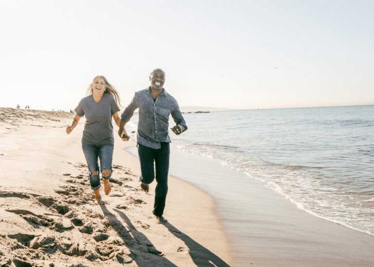 Retired couple running on the beach