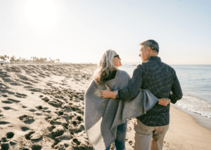 Retired couple hugging on the beach