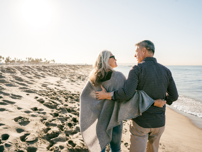Retired couple hugging on the beach