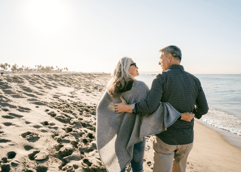 Retired couple hugging on the beach