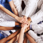 healthcare professionals with hand in a circle