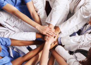 healthcare professionals with hand in a circle