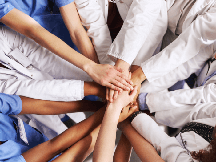 healthcare professionals with hand in a circle