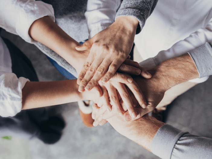 family members with hands in a circle supporting eachother