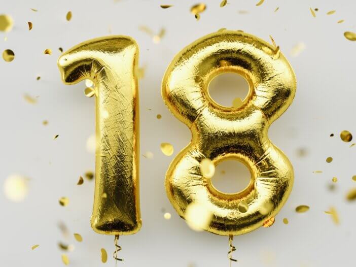 there are gold balloons that say 18 to signify that the person is becoming an adult.