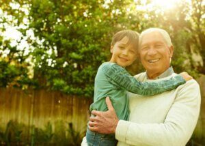 a picture of a grandpa holding his grandson hugging.