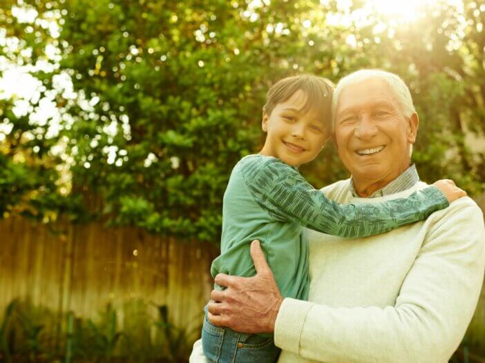 a picture of a grandpa holding his grandson hugging.