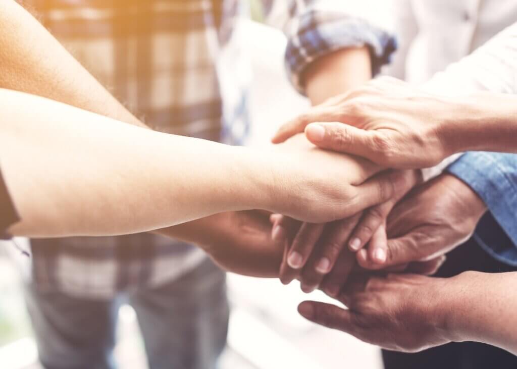 hands piled up in the center all holding each others hands
