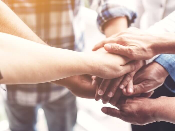 hands piled up in the center all holding each others hands