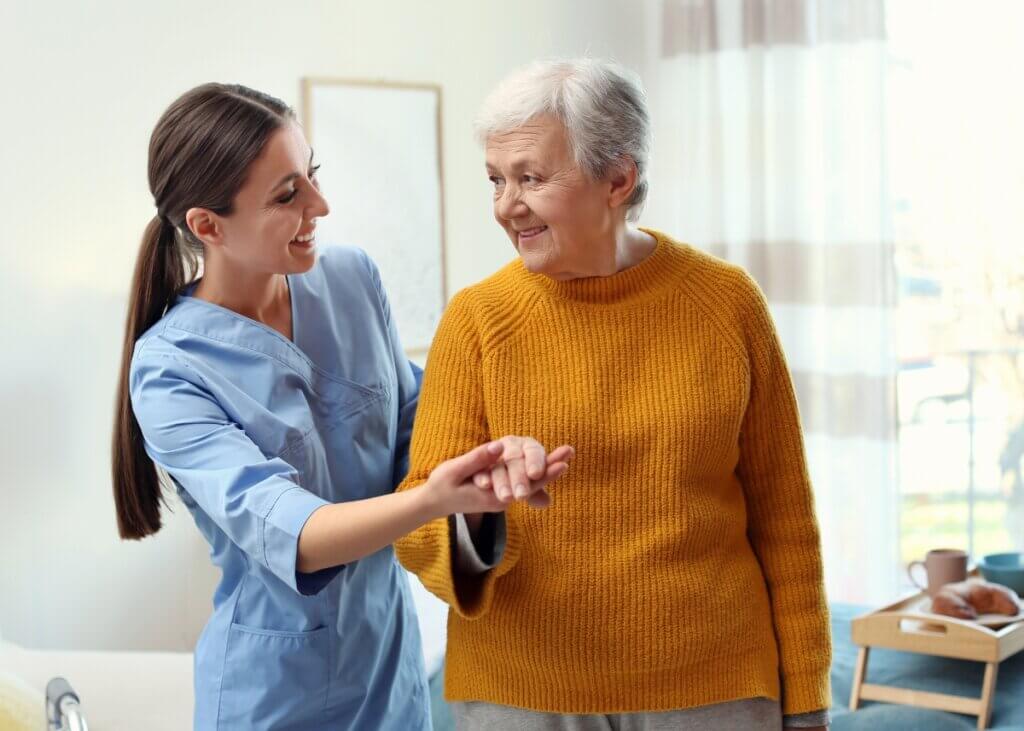 a nurse with a parkinson's patient holding hands and walking