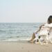 a couple hugging on the beach sitting in lounge chairs