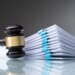 a gavel next to a stack of court papers