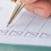 a checklist and a pen marking off the boxes with a check mark