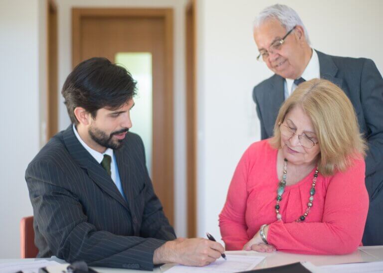 an older couple planning with their lawyer signing papers