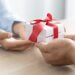 a person holding a gift and giving it to someone