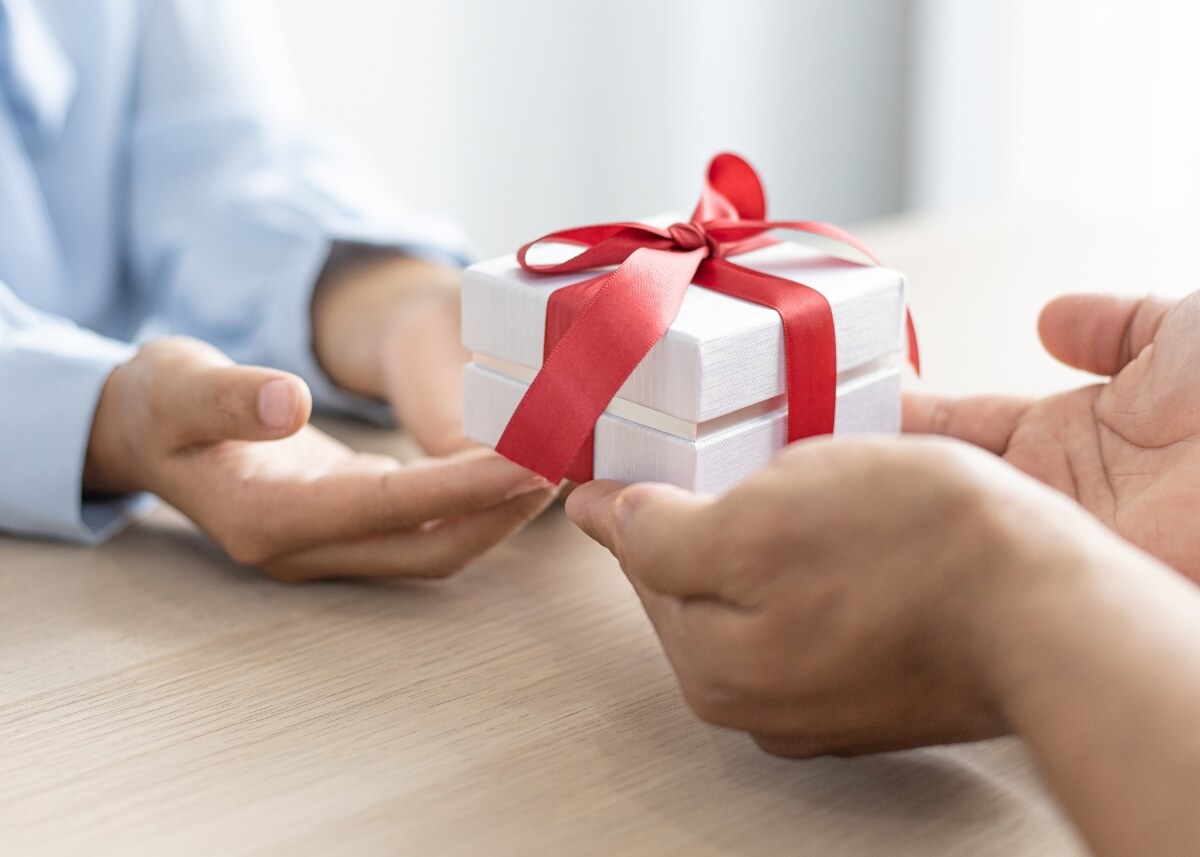 a person holding a gift and giving it to someone