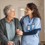 a nurse and patient in a nursing home walking down the hallway