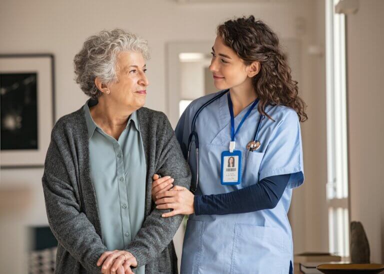 a nurse and patient in a nursing home walking down the hallway
