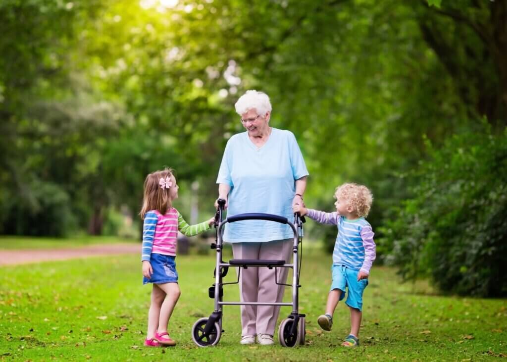 a grandmother walking on her walker with her grandkids on each side of her