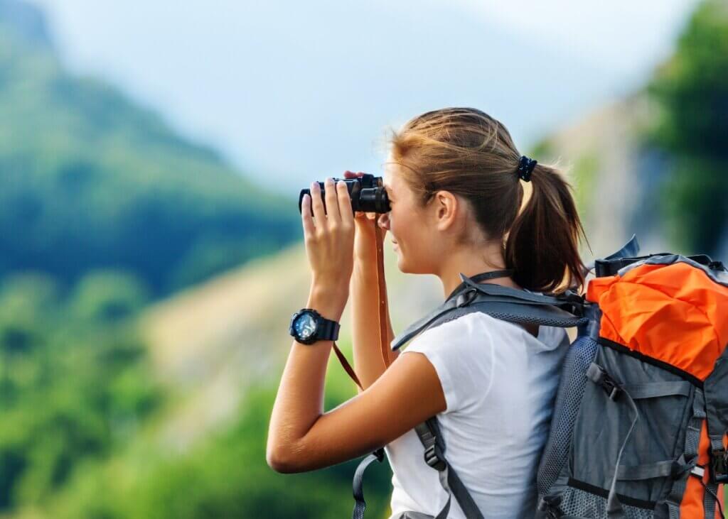 a person on vacation with their binoculars looking out at the scenery.
